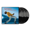Queen - Live At Wembley Stadium vinyl record album with the square cover art showing Freddie Mercury in a yellow jacket and white pants against a blue stadium background, alongside two black vinyl records partially visible.